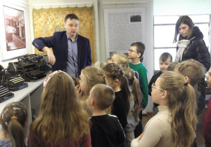 Pan Arkadiusz pokazuje dzieciom stare maszyny do pisania.